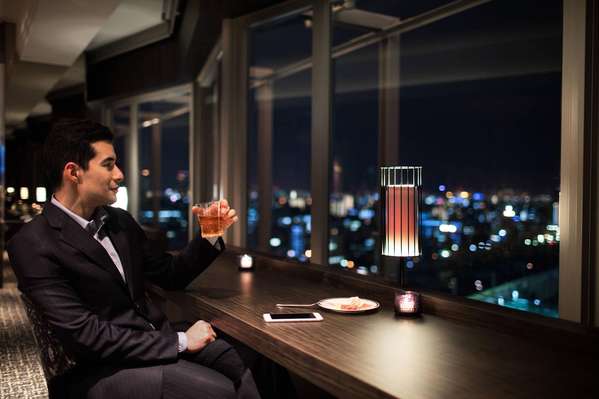 Courtyard By Marriott Shin-Osaka Station Hotel Kültér fotó A man drinking at a bar